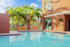 a swimming pool in front of a building with palm trees at Hampton Inn & Suites Tampa Ybor City Downtown in Tampa