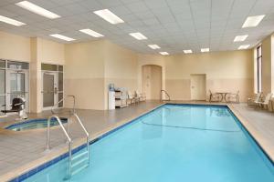 a swimming pool in a room with chairs and tables at Embassy Suites Boston at Logan Airport in Boston