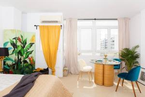 Un dormitorio con una cama y una mesa y sillas. en Palm Suite, en Torremolinos