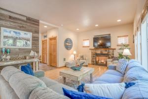 a living room with blue couches and a fireplace at Pelicans Perch Pacific City - Meredith Lodging in Pacific City