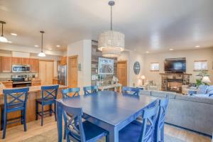 a kitchen and living room with a blue table and chairs at Pelicans Perch Pacific City - Meredith Lodging in Pacific City