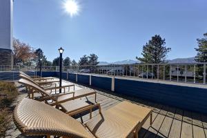 a row of wooden benches sitting on a deck at Embassy Suites by Hilton Colorado Springs in Colorado Springs