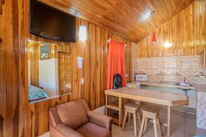 cocina con paredes de madera, mesa y sillas en Monteverde Villa Lodge, en Monteverde