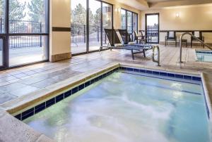 a swimming pool in the middle of a building with a patio at Hampton Inn Loveland in Loveland