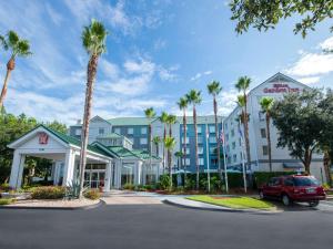 un coche aparcado frente a un hotel con palmeras en Hilton Garden Inn Jacksonville JTB/Deerwood Park, en Jacksonville