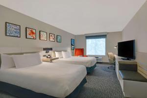 een hotelkamer met 2 bedden en een flatscreen-tv bij Hilton Garden Inn Jacksonville JTB/Deerwood Park in Jacksonville