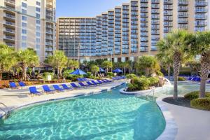 a swimming pool with lounge chairs and a resort at Royale Palms Condominiums in Myrtle Beach