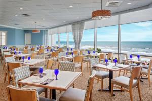 un comedor con mesas y sillas y el océano en Royale Palms Condominiums en Myrtle Beach