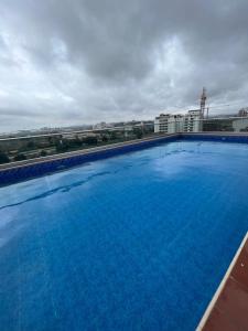 uma grande piscina azul no topo de um edifício em Lovely & cozy 1 bedroom serviced apartment em Acra