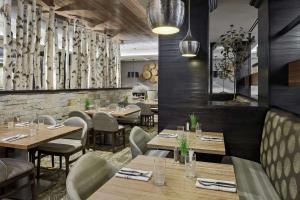 a dining room with wooden tables and chairs at DoubleTree by Hilton Hotel Denver in Denver