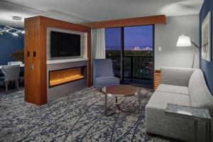 een woonkamer met een bank en een open haard bij DoubleTree by Hilton Hotel Denver in Denver