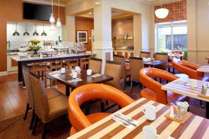 a restaurant with tables and chairs and a bar at Hilton Garden Inn Savannah Midtown in Savannah