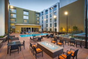 an outdoor patio with tables and chairs and a pool at Hilton Garden Inn Burbank Downtown in Burbank