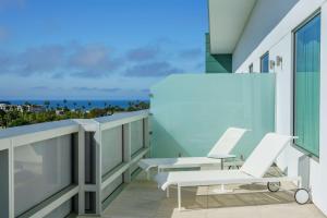 a balcony with white chairs and a view of the ocean at Hampton Inn & Suites Santa Monica in Los Angeles
