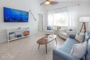 a living room with a blue couch and a table at Dual En-Suite Corner Unit - Sunrise Views in Fort Pierce