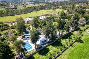 an aerial view of a house with a pool and trees at San Jose De Puembo Quito Airport, An Ascend Hotel Collection in Puembo