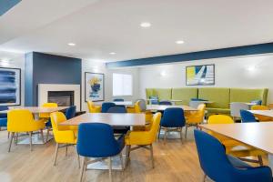 una sala de espera con mesas y sillas amarillas en Comfort Inn Near Indiana Premium Outlets en Edinburgh