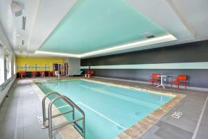 uma grande piscina com cadeiras e uma mesa em Tru By Hilton Chicopee Springfield em Chicopee