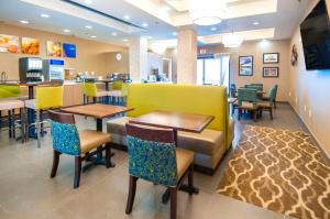 a restaurant with tables and chairs and a counter at Comfort Suites New Orleans East in New Orleans