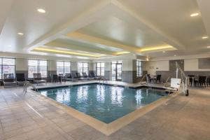 uma piscina no átrio do hotel com cadeiras e mesas em Homewood Suites by Hilton Boston Marlborough em Berlin