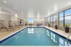 a pool in a hotel with chairs and tables at Hampton Inn Sikeston in Sikeston