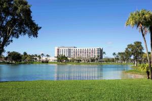 een groot gebouw naast een meer met palmbomen bij Hilton Miami Dadeland in South Miami