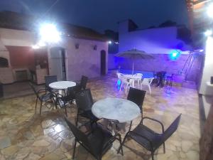 un patio al aire libre con mesas y sillas por la noche en CASA MATTOS en São Pedro da Aldeia