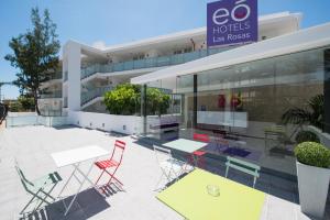 a building with tables and chairs in front of it at eó Las Rosas in Playa del Ingles