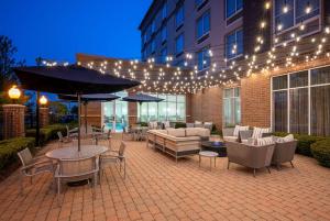 a patio with tables and chairs and an umbrella at DoubleTree by Hilton Chicago Midway Airport, IL in Bedford Park