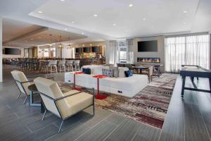 Bedford ParkにあるDoubleTree by Hilton Chicago Midway Airport, ILの白いソファと椅子付きの広いリビングルーム
