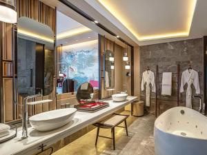 a bathroom with two sinks and a bath tub at Swissotel The Stamford in Singapore