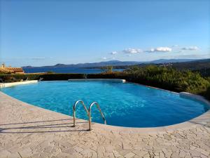 a large swimming pool with a view of the water at Sherden - Esmeralda Luxury Apartment in Santa Marinella