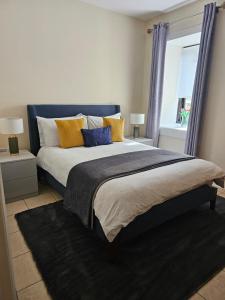 sypialnia z dużym łóżkiem z żółtymi i niebieskimi poduszkami w obiekcie The Koze w mieście Leitrim