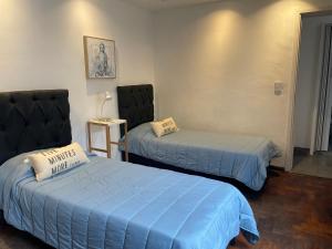 Habitación con 2 camas y sábanas azules. en Departamento Sol y Vino, en Mendoza