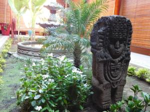 a statue in front of a garden with plants at Habitaciones - Casa Lester in Granada