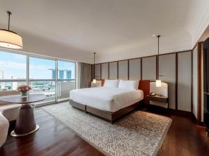 um quarto com uma cama grande e uma janela grande em Fairmont Singapore em Singapura