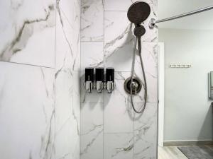 a bathroom with a shower with white marble walls at Magical Sunset waterfront view, renovated 3bd 2bth in Clearwater Beach