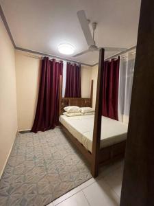 1 Schlafzimmer mit 2 Etagenbetten mit roten Vorhängen in der Unterkunft The Tropics Apartment Mombasa in Mombasa