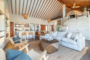 uma sala de estar com um sofá e uma mesa em Conch Shell Cottage and The PoolClub at Mahogany Bay! em San Pedro