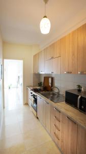 a kitchen with wooden cabinets and a black microwave at Sea view apartement in Durrës