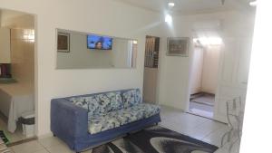 uma sala de estar com um sofá azul num quarto em Casa Aconchegante em Maresias