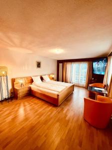 ein großes Schlafzimmer mit einem großen Bett und Holzböden in der Unterkunft Apartment with balcony and Panoramic Views of Alps in Klosters Serneus