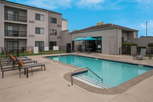 ein Pool mit Bänken und ein Gebäude in der Unterkunft Best Western Spartanburg Northwest in Spartanburg