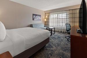 スパータンバーグにあるBest Western Spartanburg Northwestのベッドとデスクが備わるホテルルームです。