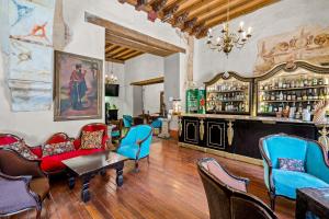 a room with a bar with chairs and a table at Quinta Real Puebla in Puebla