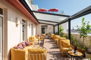 - une terrasse avec un bouquet de chaises et de tables dans l'établissement Hotel Montera Madrid, Curio Collection By Hilton, à Madrid