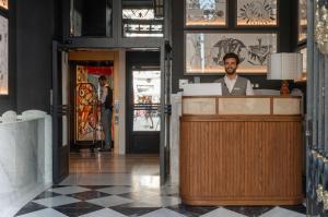 Un homme debout derrière un comptoir dans un restaurant dans l'établissement Hotel Montera Madrid, Curio Collection By Hilton, à Madrid