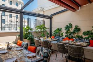 马德里Hotel Montera Madrid, Curio Collection By Hilton的阳台上摆着桌椅的餐厅