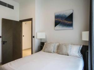 een slaapkamer met een groot wit bed en een spiegel bij Gorgeous 2 bedroom in Binghatti, Business Bay in Dubai