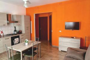 a kitchen with a table and a kitchen with orange walls at Casa Vacanze Margherita in Caltagirone +7 photos